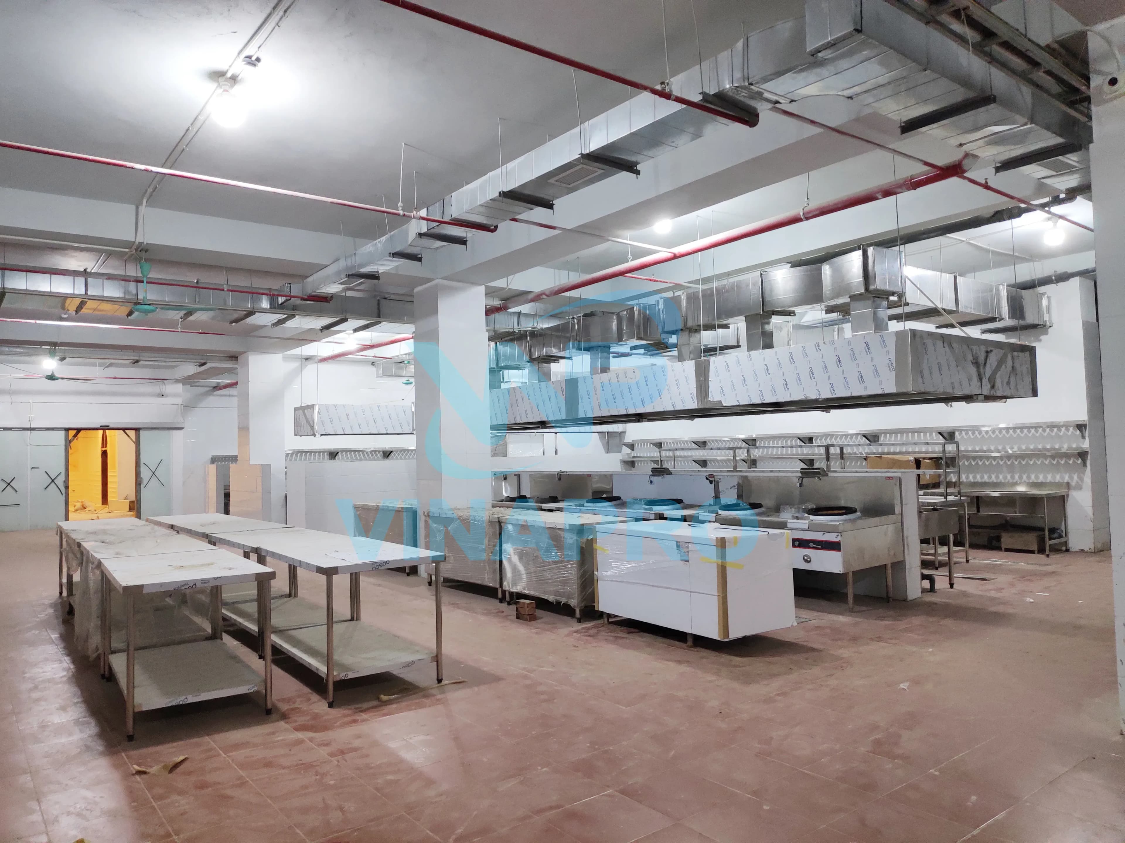 Khu vực quầy bếp trung tâm, có bếp á, tum hút mùi, quầy kệ để thực phẩm đã sơ chế, tủ mát bàn chặt để chế biến đồ